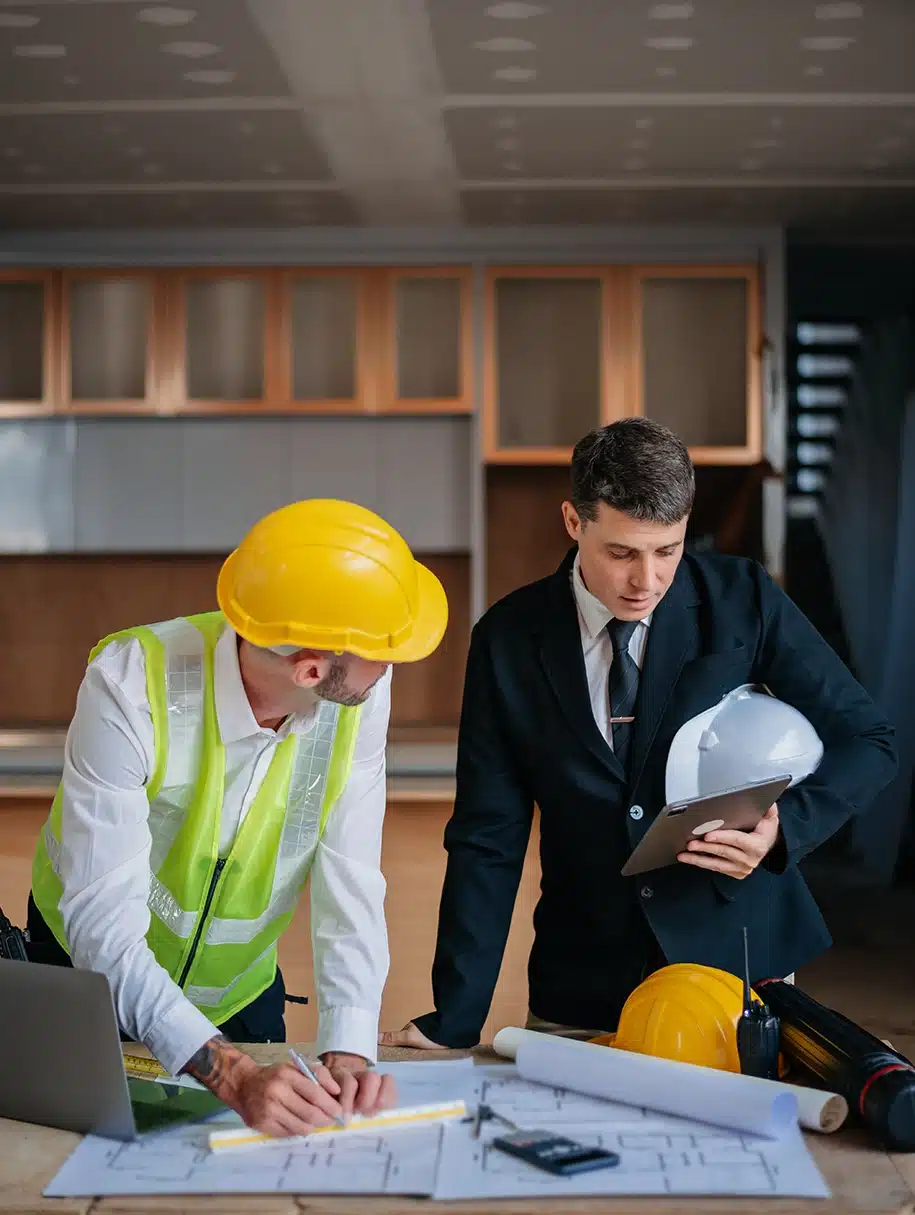 Ingenieurteams, die Arbeiterhelme tragen und sich ihr Projekt besprechen