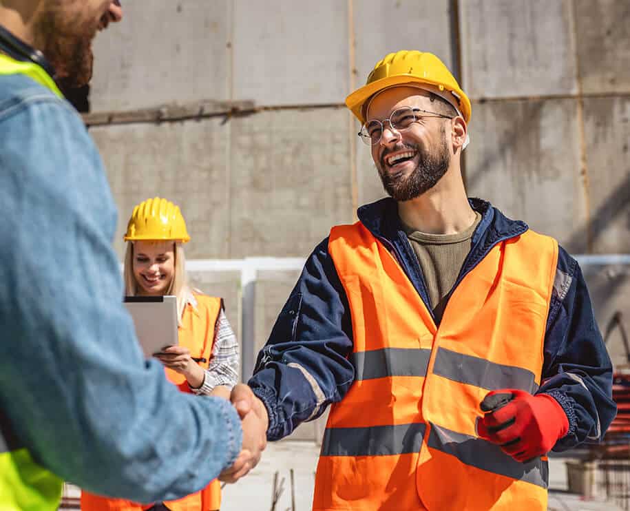 Bauarbeiter reichen sich die Hand