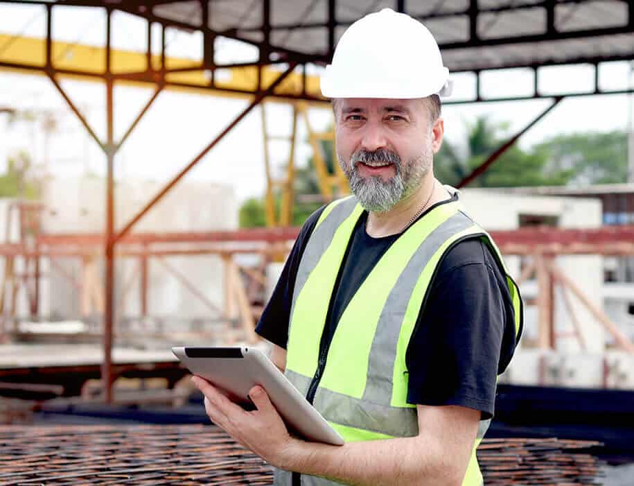 Mann nutzt Tablet auf Baustelle