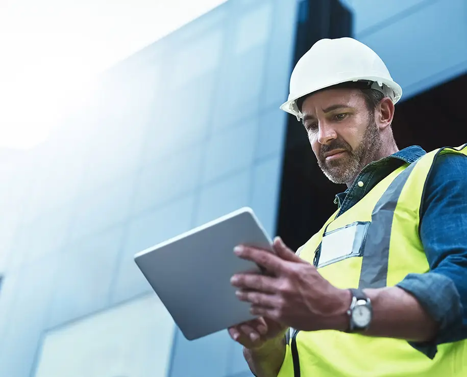 Ein Bauingenieur mit Tablet vor einem Gebäude