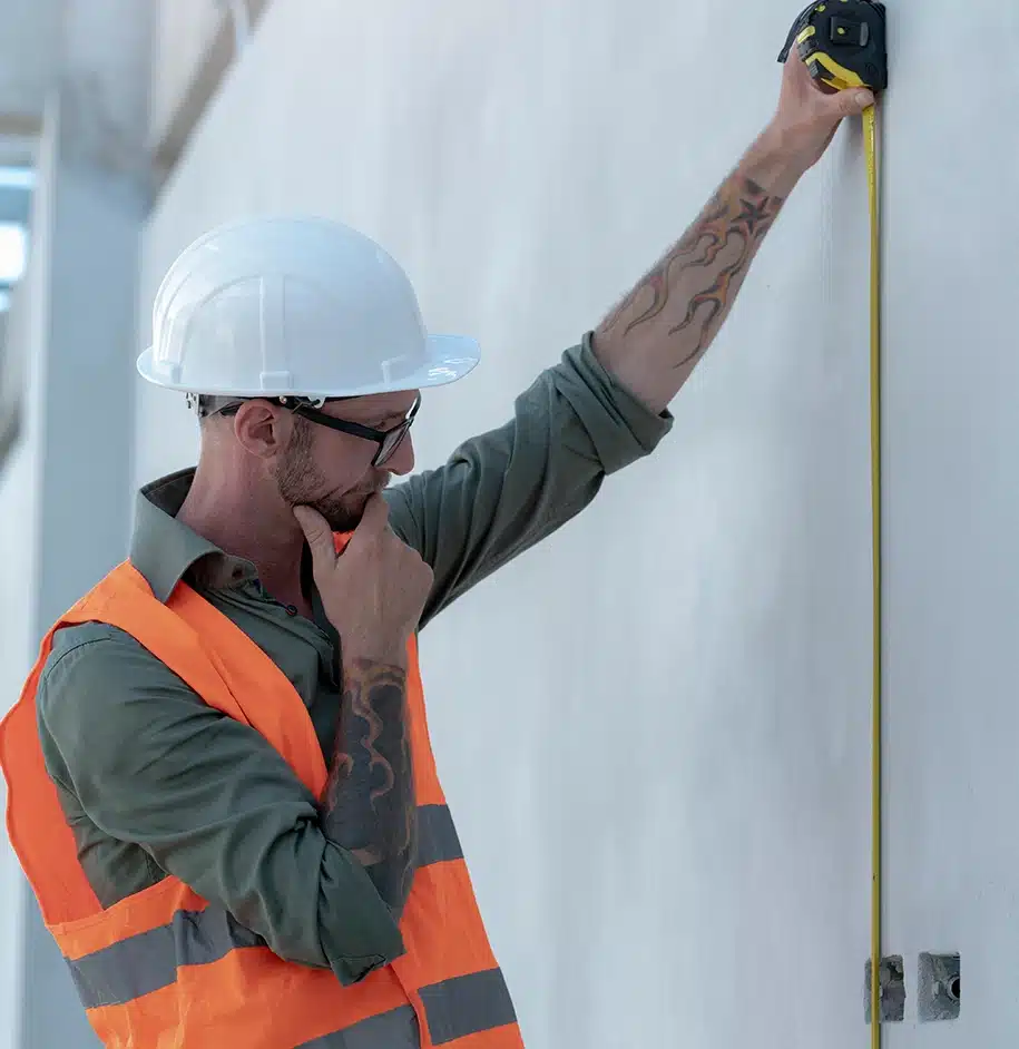 Der Ingenieur inspiziert aufmerksam die Gebäudewände.