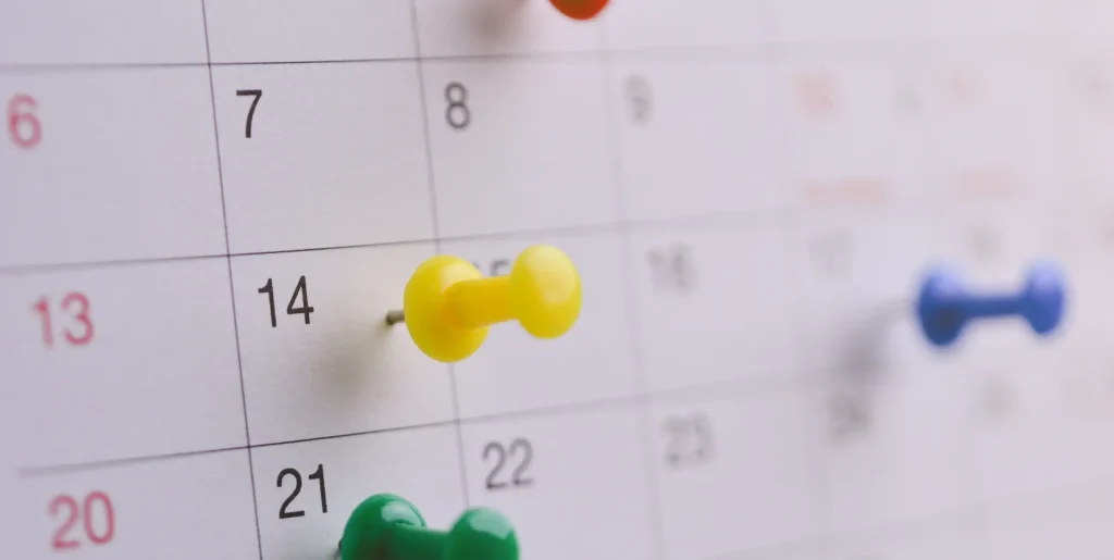 Pins stecken auf einem Wandkalender
